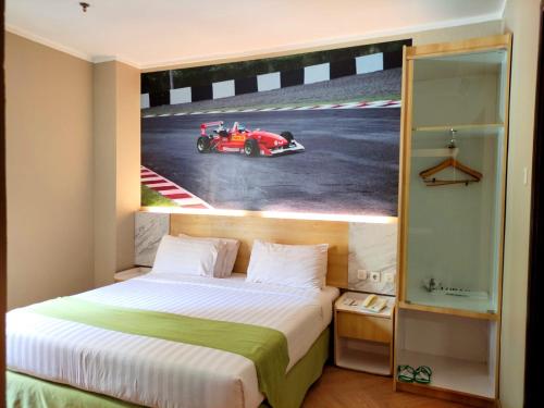 - une chambre avec un lit et une photo de voiture de course dans l'établissement Syariah Hotel Sentul, à Bogor
