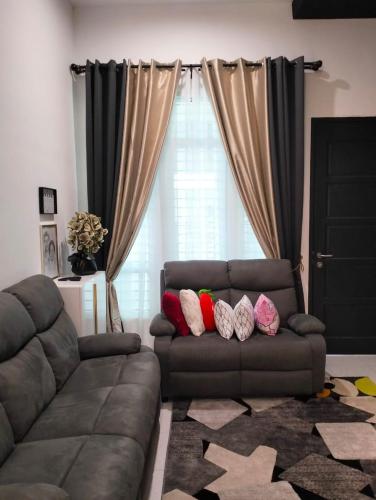 a living room with a couch with pillows on it at Asmar's Homestay Alor Setar in Alor Setar
