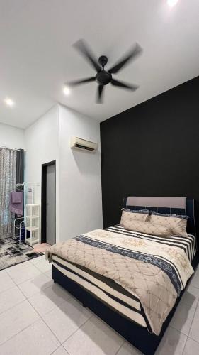 a bedroom with a bed with a ceiling fan at Asmar's Homestay Alor Setar in Alor Setar