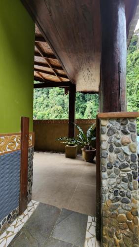 a room with a stone pillar and a green wall at Sam's Bungalows And Treks in Bukit Lawang
