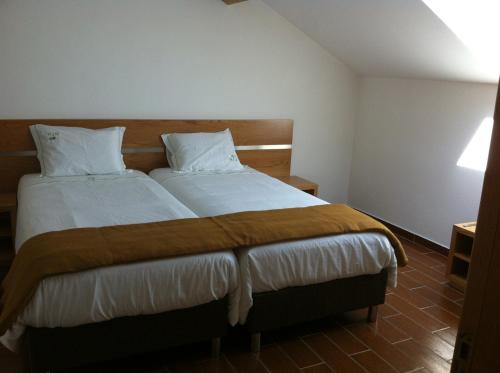 a bedroom with a large bed with white sheets and pillows at Gites Des Sablons in Châtillon-sur-Marne