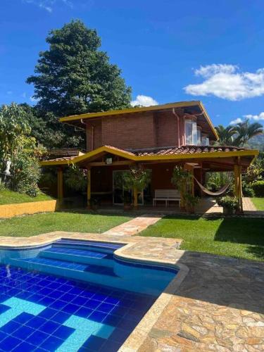 a house with a swimming pool in front of a house at Charming villa near to Medellín Metro and malls in Copacabana