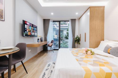 a hotel room with a large bed and a desk at Margaery Boutique Apartment & Skyon9 Rooftop Bar in Hanoi