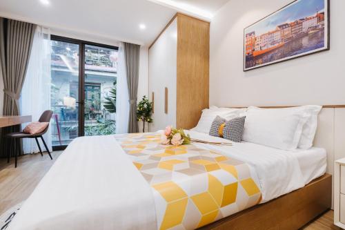 a hotel room with a large bed and a desk at Margaery Boutique Apartment & Skyon9 Rooftop Bar in Hanoi