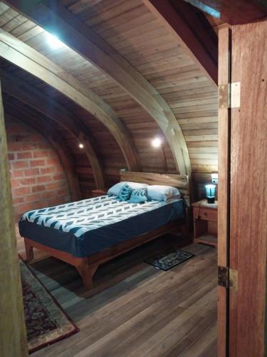 a bedroom with a bed in a wooden room at Hacienda Aventuras en el Paraíso in Quito
