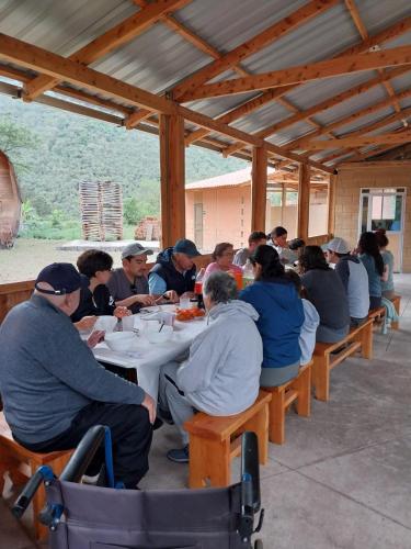een groep mensen die aan een tafel zitten te eten bij Hacienda Aventuras en el Paraíso in Quito