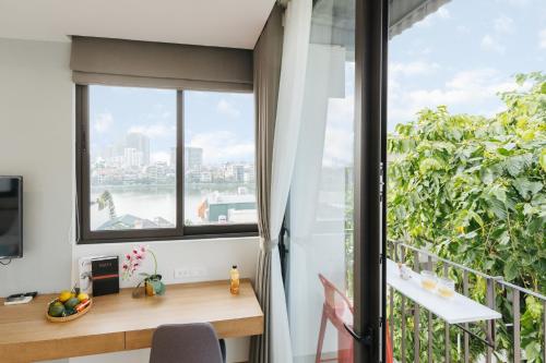 a room with a balcony with a desk and a window at Margaery Boutique Apartment & Skyon9 Rooftop Bar in Hanoi
