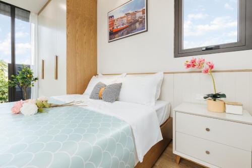 a bedroom with a white bed and a window at Margaery Boutique Apartment & Skyon9 Rooftop Bar in Hanoi