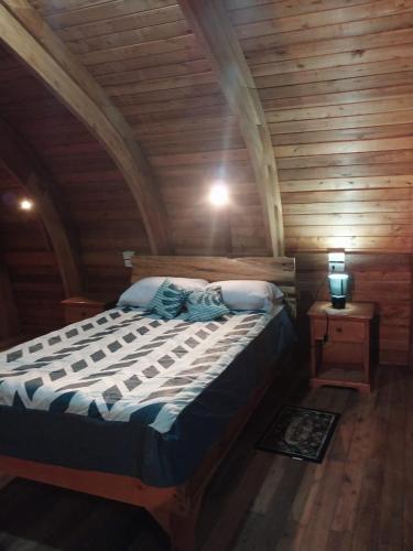 a bedroom with a large bed in a wooden room at Hacienda Aventuras en el Paraíso in Quito