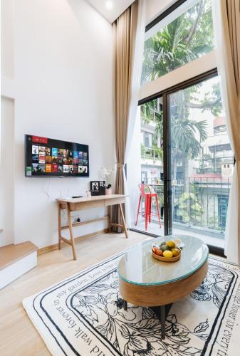 a living room with a table and a large window at Margaery Boutique Apartment & Skyon9 Rooftop Bar in Hanoi