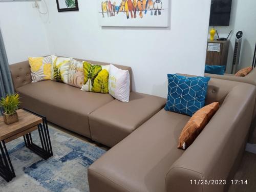 a brown couch with pillows on it in a living room at 1 BR Centrio Tower 926 in Cagayan de Oro
