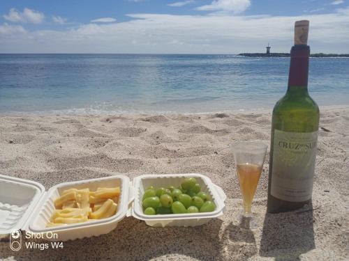 eine Flasche Wein, ein Tablett mit Essen und eine Flasche Champagner in der Unterkunft Island Suites in Puerto Baquerizo Moreno