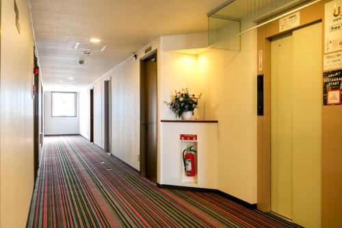 a hallway of an office building with a coke machine at Business Hotel Nishine in Hachimantai
