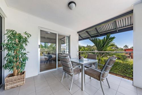 a dining room with a table and chairs on a balcony at Casa Ava Airlie in Airlie Beach