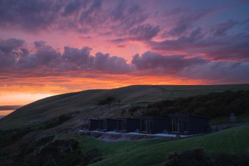 a house on top of a hill at sunset at The Cove Tasmania in Devonport