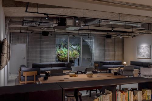 a library with couches and a table with books at RAKURO Kyoto by THE SHARE HOTELS in Kyoto