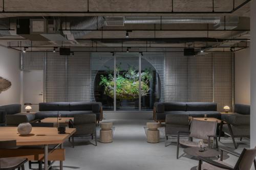 a room with chairs and tables and a window at RAKURO Kyoto by THE SHARE HOTELS in Kyoto