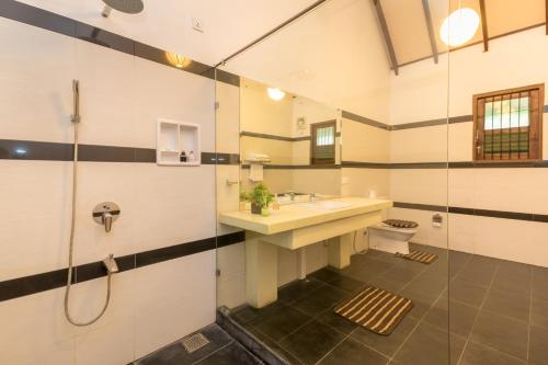 uma casa de banho com um lavatório e um chuveiro em Yala Chalets by Lalan Leisure em Kirinda
