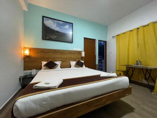 a bedroom with a large bed with a yellow curtain at EDEN Paradisee in Ooty