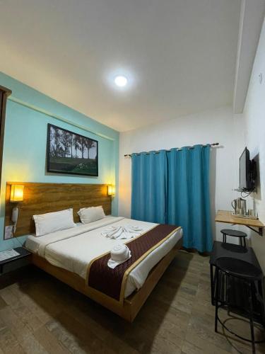 a bedroom with a large bed with blue walls at EDEN Paradisee in Ooty