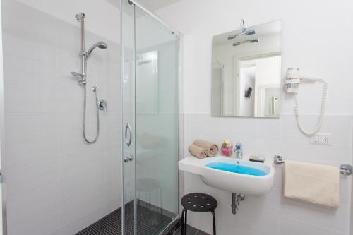 a white bathroom with a sink and a shower at Hotel Star in Cesenatico