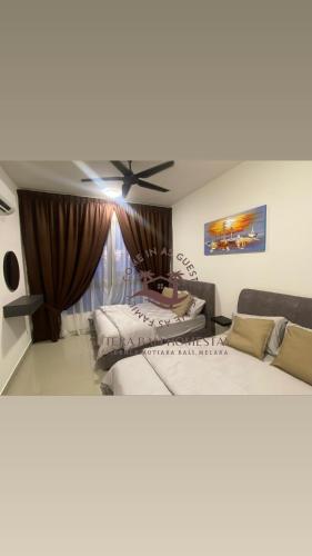 two beds in a room with a ceiling fan at SuteraMuslimHomestay Bali Residence Melaka in Melaka