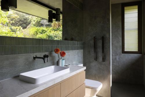 a bathroom with a white sink and a toilet at Moonrise in Byron Bay