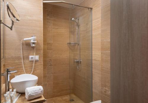 a bathroom with a toilet and a glass shower at Republica Hotel Yerevan in Yerevan