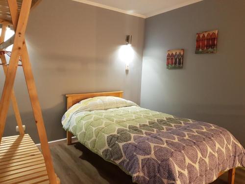 een slaapkamer met een bed en een houten ladder bij Cabañas Piedra Negra, Los Molles in La Ligua