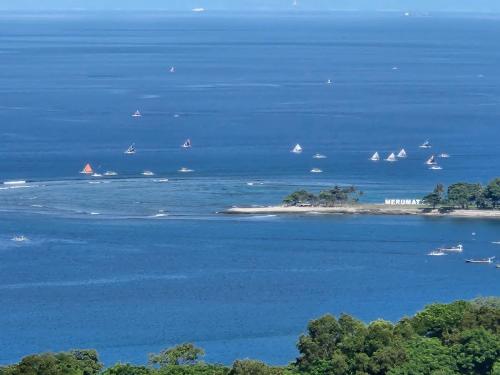an island with boats in the water with sailboats at Villa Umbrella Lombok in Senggigi 
