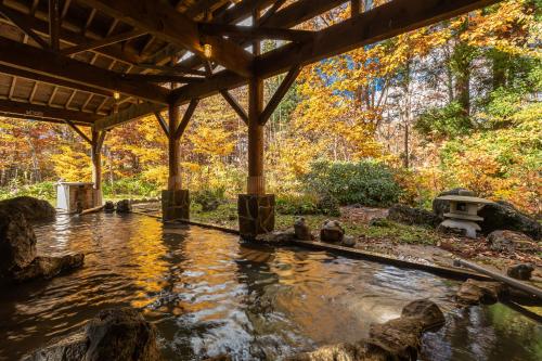 a pond in the middle of a garden at KAMENOI HOTEL Tazawako in Senboku
