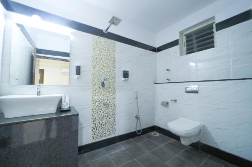 a bathroom with a sink and a toilet at Hotel CN Windsor Chikmagaluru in Chikmagalūr