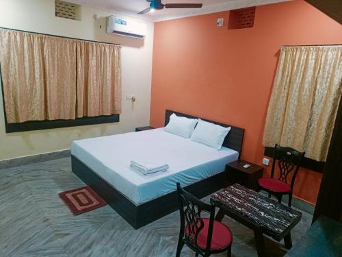 um quarto com uma cama, uma mesa e cadeiras em VENTURE INN em Bhubaneshwar