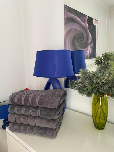 a table with a lamp and a pile of towels at Blue light ultracentral in Craiova