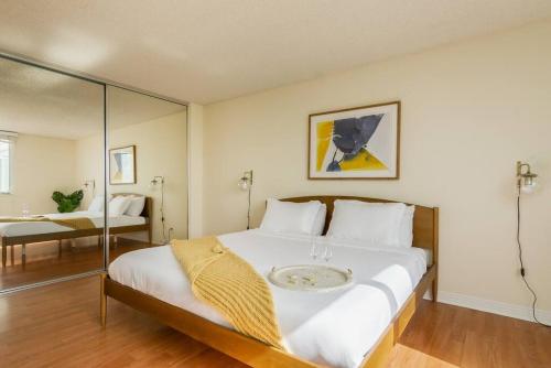 1 dormitorio con 1 cama blanca grande y espejo en Panoramic Penthouse Venice/ Marina Del Rey., en Los Ángeles