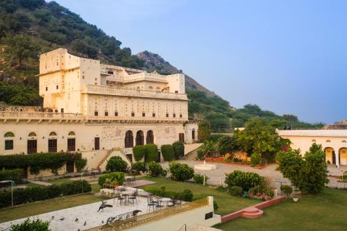 a large building in front of a mountain at Castle Kalwar in Pachār