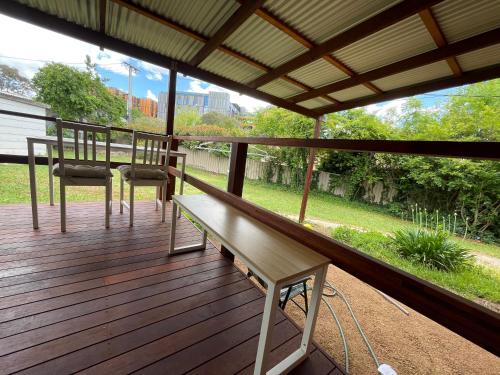 a wooden deck with a bench and chairs on it at Canberra Hospital Locum Welcome - Home in Harman