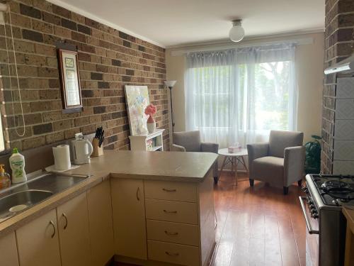 a kitchen with a counter top and a living room at Canberra Hospital Locum Welcome - Home in Harman