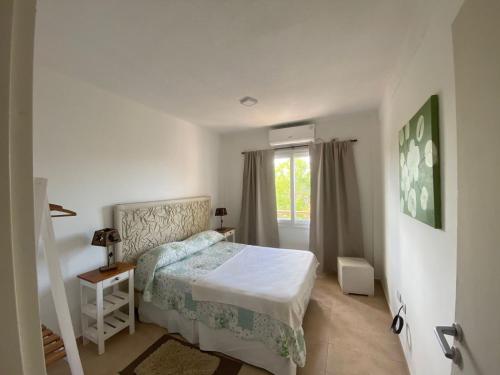 a white bedroom with a bed and a window at Cielo in Concepción del Uruguay