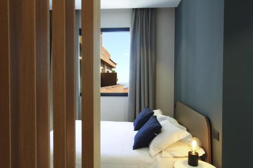 a bedroom with a bed with blue walls and a window at Ollen apartments in Catania