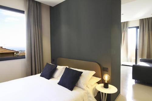a bedroom with a bed with blue pillows and a window at Ollen apartments in Catania