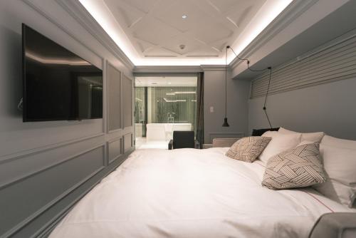 a bedroom with a large white bed with a flat screen tv at Y11 azabu hotel by Mrt in Tokyo