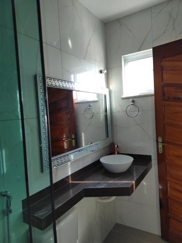 a bathroom with a sink and a mirror at Casa Tropicana (2º andar) in Flecheiras