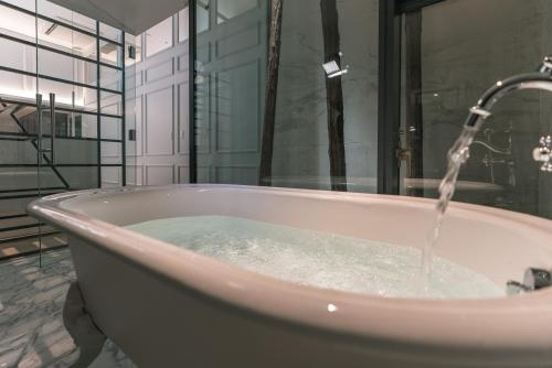 a bath tub with water coming out of it at Y11 azabu hotel by Mrt in Tokyo