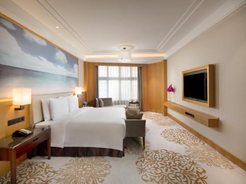 a hotel room with a large bed and a television at Xiamen C&D Hotel-Free Welcome Snacks-Oasis Garden in Xiamen