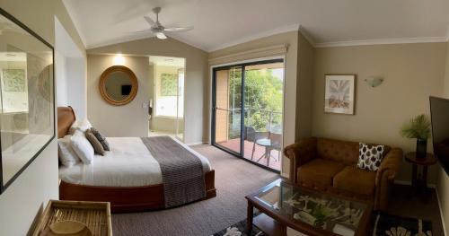 a bedroom with a bed and a sliding glass door at Top Of The Hill in Maleny