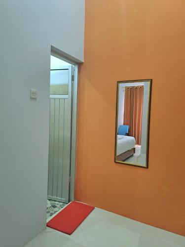 a room with a mirror and a red rug at Kresna Guest House Syariah Pacitan in Pacitan