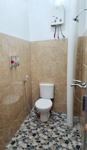 a bathroom with a toilet and a shower at Kresna Guest House Syariah Pacitan in Pacitan