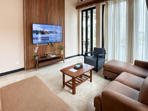 a living room with a couch and a tv at Bonheur at Karambunai in Kota Kinabalu