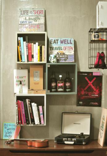 a book shelf with books and a computer on a desk at Beach People Hostel Bantayan Island in Ocoy